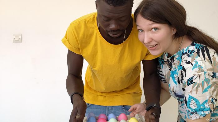 Ein Mann und eine Frau halten einen Karton mit bunt gefärbten Eiern