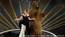 12.03.2023 *** Elizabeth Banks, left, and an actor dressed in a costume from her movie Cocaine Bear present the award for best visual effects at the Oscars on Sunday, March 12, 2023, at the Dolby Theatre in Los Angeles. (AP Photo/Chris Pizzello)