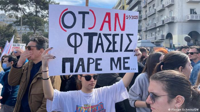 Eine Demonstrantin hält ein Schild in die Höhe mit der griechischen Aufschrift: Ruf mich an, wenn (falls) Du ankommst - diese SMS an eines der Opfer ist in Griechenland zum Sinnbild der Zugkatastrophe geworden