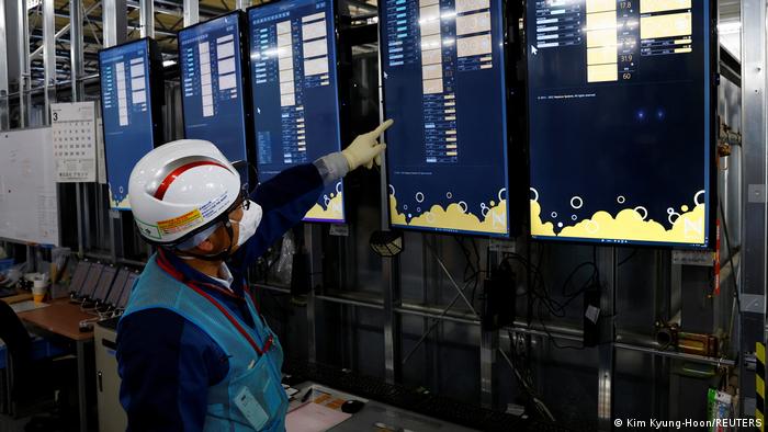 A Tepco employee points to a monitor at the former Fukushima Dai-ichi nuclear power plant.