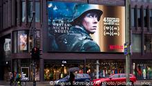 13.03.2023 *** People walk in front of a promotional screen showing a scene from the Oscar-winning film Im Westen nichts Neues - All Quiet on the Western Front in Berlin, Germany, Monday, March 13, 2023. The German film wins four Oscars, including for Best International Feature Film at the 2023 Academy Awards. (AP Photo/Markus Schreiber)