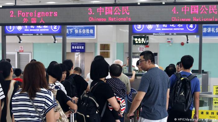 Menschen vor Einreiseschaltern mit chinesischen Schriftzeichen
