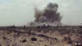 A dust cloud is seen following the explosion of a missile, outside the strategic oil port of Brega, Libya, Thursday, April 7, 2011