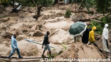 Menschen überqueren einen Fluss in Blantyre. Der außergewöhnlich langlebige Tropensturm «Freddy» hat zum zweiten Mal innerhalb eines Monats im Südosten Afrikas eine Spur der Verwüstung hinterlassen. In Malawi kamen mindestens 56 Menschen ums Leben, wie der staatliche Fernsehsender MBC mitteilte. +++ dpa-Bildfunk +++