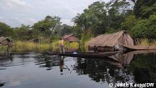 14/12/2022 Im Dorf Mpeka am Fluss Ruki, Provinz Équateur, DR Kongo aufgenommen.
Ein Junge paddelt vor der Hütte des Fischers Jean Paul Ikolongo vorbei