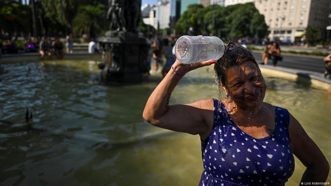 Ola de calor en Buenos Aires: una mujer se refresca con agua en la cabeza.