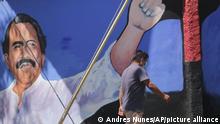 A man walks past a mural of Nicaraguan President Daniel Ortega during general elections in Managua, Nicaragua, Sunday, Nov. 7, 2021. Ortega seeks a fourth consecutive term against a field of little-known candidates while those who could have given him a real challenge sit in jail. (AP Photo/Andres Nunes)