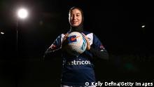 Eine Fußballerin in Trikot und mit einem Fußball in der Hand lächelt selbstbewusst in die Kamera. (Quelle: Kelly Defina/Getty Images)