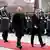 German Chancellor Olaf Scholz and Swedish Prime Minister Ulf Kristersson walk along red carpet in Berlin in front of soldiers standing attention
