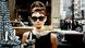 In this film still from "Breakfast at Tiffany's," Audrey Hepburn wears dark sunglasses and a diamond necklace as she looks at diamonds in a store's window display. In this film still from "Breakfast at Tiffany's," Audrey Hepburn wears dark sunglasses and a diamond necklace as she looks at diamonds in a store's window display.