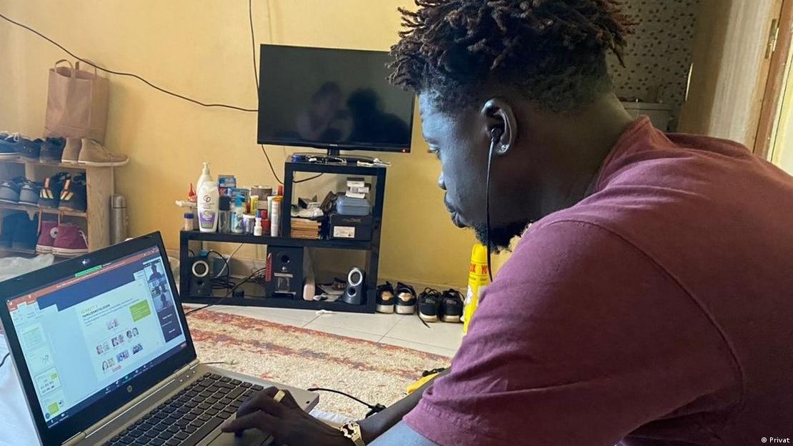 Moro Diop sitting at his laptop at home, a German language program is on the screen