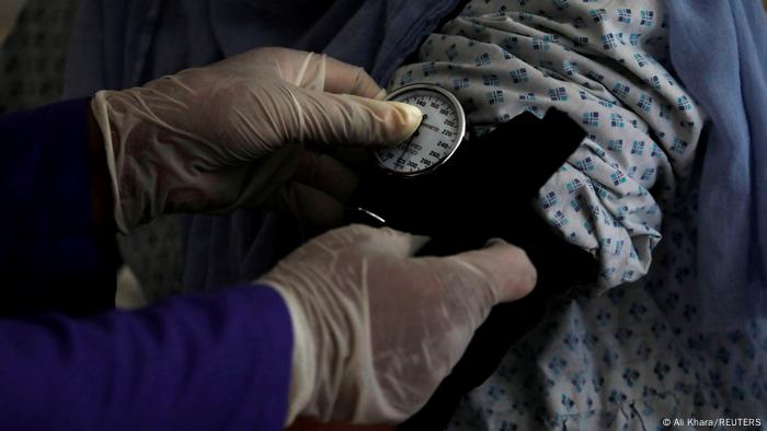 Eine Hebammenschülerin misst den Blutdruck einer schwangeren Patientin.