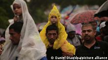 Männer tragen Kinder auf ihren Schultern, als sie zusammen mit zahlreichen Migranten unter dem Regen zu Fuß in Richtung Norden aufbrechen. Nach lokalen Medienberichten sind darunter viele Venezolaner, die aus ihrem Land ausgewandert sind.