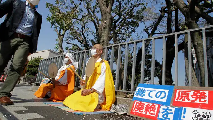 Buddhistische Mönche sitzen auf der Straße vor der Residenz von Naoto Kan in Tokio (Foto: AP)