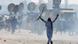 A man walks with a raised stick amid tear gas smoke during Pakistan protests A man walks with a raised stick amid tear gas smoke during Pakistan protests