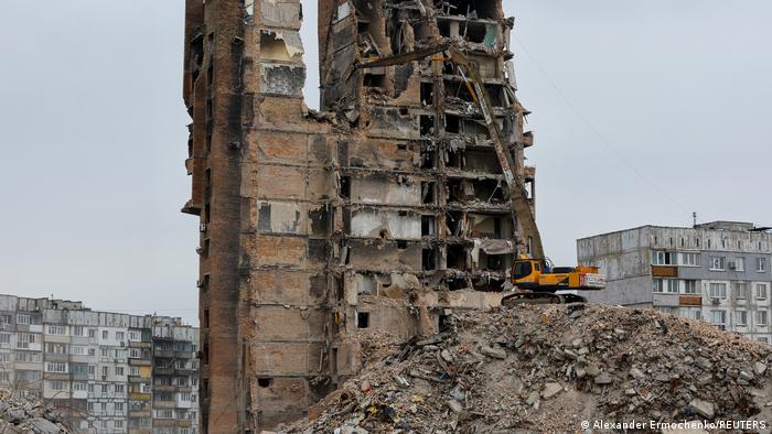 Ein Bagger reißt ein zerstörtes Haus in Mariupol ab (März 2023)