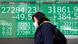 A woman walks in front of the Nikkei building in Tokyo A woman walks in front of the Nikkei building in Tokyo