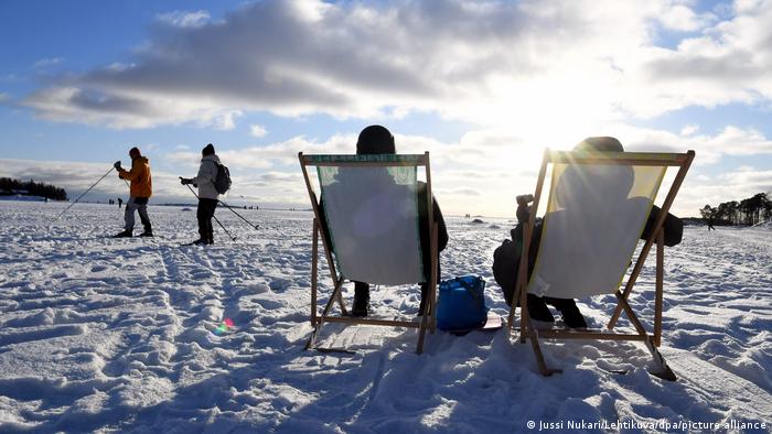 Os finlandeses apreciam sentar-se ao sol em plena neve no mês de fevereiro em Helsinque