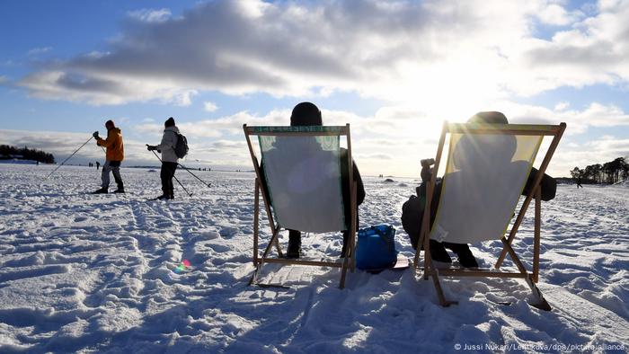 Os finlandeses apreciam sentar-se ao sol em plena neve no mês de fevereiro em Helsinque