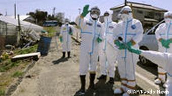 Chief Cabinet Secretary Yukio Edano, second right, tours Minamisoma, Fukushima Prefecture wearing protective clothing