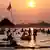 Tourists enjoy the low running Mekong River at sunset on the border of the two Southeast Asian nations