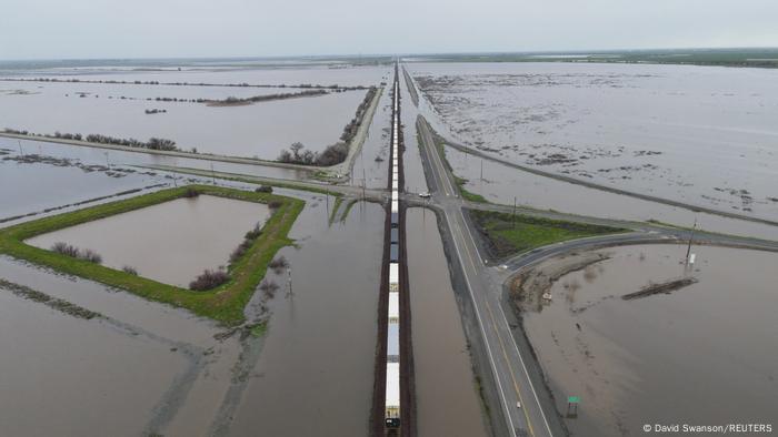 Ein Zug fährt über Gleise, die von den Fluten des Tule River nach tagelangen schweren Regenfällen in Corcoran, Kalifornien, USA, völlig überflutet sind