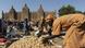 Une femme travaille sur un marché près de la Mosquée de Djenne Une femme travaille sur un marché près de la Mosquée de Djenne