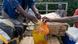 People holding canisters of cooking oil and other foodstuffs