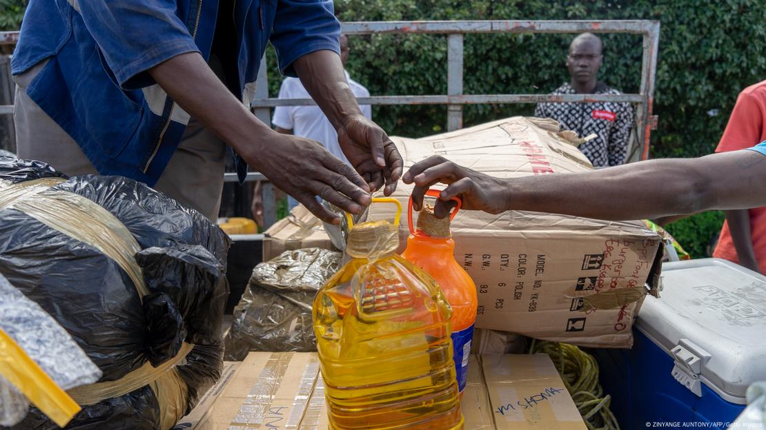 People holding canisters of cooking oil and other foodstuffs