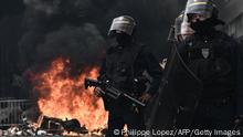 Anti-riot police officers stand guard next to a fire set by protesters during a demonstration on a national action day, a week after the government pushed a pensions reform through parliament without a vote, using the article 49.3 of the constitution, in Bordeaux, southwestern France, on March 23, 2023. - French President defiantly vowed to push through a controversial pensions reform on March 22, 2023, saying he was prepared to accept unpopularity in the face of sometimes violent protests. (Photo by Philippe LOPEZ / AFP) (Photo by PHILIPPE LOPEZ/AFP via Getty Images)