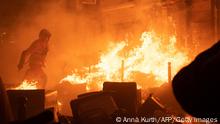 A firefighter tries to extinguish a fire during a demonstration, a week after the government pushed a pensions reform through parliament without a vote, using the article 49.3 of the constitution, in Paris on March 23, 2023. - Some 1.089 million protesters took part in demonstrations in France on March 23, 2023, against President Emmanuel Macron's pension reform, the interior ministry said, with 119,000 marching in Paris alone. (Photo by Anna KURTH / AFP) (Photo by ANNA KURTH/AFP via Getty Images)