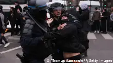French Police officers clash with a protester (C) during a demonstration, a week after the government pushed a pensions reform through parliament without a vote, using the article 49.3 of the constitution, in Paris on March 23, 2023. - French unions on March 23, 2023, staged a new day of disruption against President Emmanuel Macron's pension reform after he defiantly vowed to implement the change, with refineries at a standstill and mass transport cancellations. (Photo by Thomas SAMSON / AFP) (Photo by THOMAS SAMSON/AFP via Getty Images)