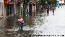 23.3.2023****A woman wades through a flooded street in the Sauces neighborhood of Guayaquil, Ecuador, Thursday, March 23, 2023. Ecuador is going through an intense winter storm that is affecting several cities in the country. (AP Photo/Cesar Munoz)