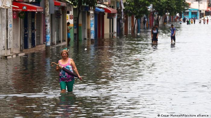 Una mujer camina a lo largo de una calle inundada en Guayaquil, Ecuador