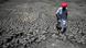 This photograph taken on May 11, 2022 shows Shivaram, a villager walking through the cracked bottom of a dried-out pond on a hot summer day at Bandai village in Pali district This photograph taken on May 11, 2022 shows Shivaram, a villager walking through the cracked bottom of a dried-out pond on a hot summer day at Bandai village in Pali district