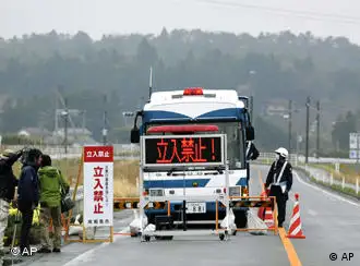 Police officers man a checkpoint with an electric sign board with Japanese words reading, Off Limits, set up at a point close to a just-declared no-go zone at Minami Soma, Fukushima prefecture, Japan on Friday April 22, 2011. The government declared the no-go zone on Thursday for areas within 20 kilometers (12 miles) of the radiation-spewing Fukushima Dai-ichi nuclear plant. (AP Photo/Kyodo News) JAPAN OUT, MANDATORY CREDIT, NO LICENSING IN CHINA, HONG KONG, JAPAN, SOUTH KOREA AND FRANCE
