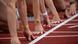 Leichtathletinnen in der Starthocke knieend, man sieht vor allem ihre Hände hinter der Startlinie. Leichtathletinnen in der Starthocke knieend, man sieht vor allem ihre Hände hinter der Startlinie.