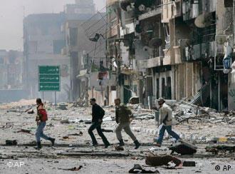 Rebels run across bombed street