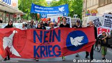 Demonstranten tragen am Samstag (23.04.2011) in München (Oberbayern) beim Ostermarschs ein Plakat mit der Aufschrift Nein zum Krieg. Mit der Protestveranstaltung wurde auch die Abschaffung von Atomwaffen und das Abschalten von Atomkraftwerken gefordert. Foto: Tobias Hase dpa/lby