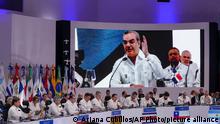 Leaders and representatives listen to Dominican Republic President Luis Abinader, pictured on large screen, during the 28th Ibero-American Summit session, in Santo Domingo, Dominican Republic, Saturday, March 25, 2022. (AP Photo/Ariana Cubillos)