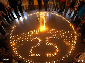 Pupils and teachers of the ecological gymnasium stand around candles lit to commemorate victims of the Chernobyl nuclear disaster in Minsk, Belarus, Monday, April 25, 2011. The blast on April 26, 1986, spewed a cloud of radioactive fallout over much of Europe and forced hundreds of thousands from their homes in the most heavily hit areas in Ukraine, Belarus and western Russia. The disaster did not become public knowledge for several days, because Soviet officials released no information until 72 hours after the accident. (AP Photo/Sergei Grits)