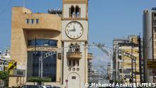 A woman walks near a clock tower that indicates the time in Jdeideh, Lebanon March 26, 2023. REUTERS/Mohamed Azakir 