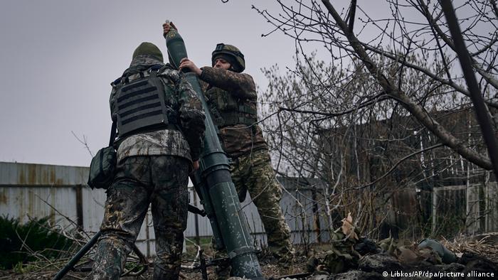 Zwei ukrainische Soldaten bereiten einen Mörser zum Abfeuern von Granaten vor 