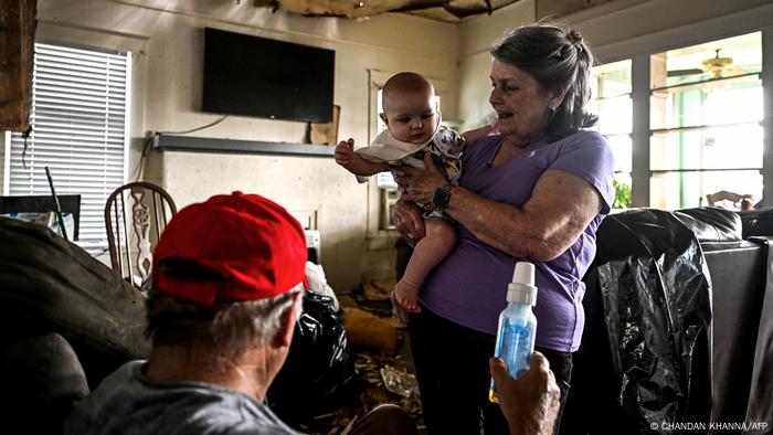 Phyllis Dawson steht mit ihrem Mann und ihrer Enkeltochter in ihrem zerstörten Haus in Silver City
