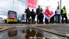 Mitarbeiter der Dresdner Verkehrsbetriebe (DVB) stehen mit Verdi Fahnen beim Warnstreik im Betriebshof Trachenberge vor Straßenbahnen. Mit einem großangelegten bundesweiten Warnstreik haben die Gewerkschaften EVG und Verdi am Montag weite Teile des öffentlichen Verkehrs lahmgelegt.