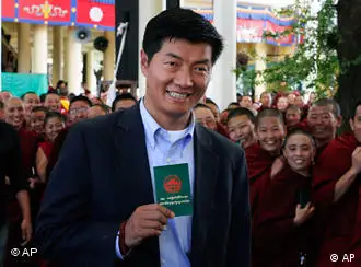 FILE- In this March 20, 2011 file photo, Tibetan prime ministerial candidate Lobsang Sengey, shows his green book as he arrives to cast his vote in Dharmsala, India. Legal expert Sangay has won the election to become head of the Tibetan government-in-exile, taking over the Dalai Lama's political role.(AP Photo/Ashwini Bhatia, File)