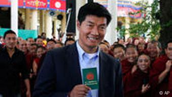 FILE- In this March 20, 2011 file photo, Tibetan prime ministerial candidate Lobsang Sengey, shows his green book as he arrives to cast his vote in Dharmsala, India. Legal expert Sangay has won the election to become head of the Tibetan government-in-exile, taking over the Dalai Lama's political role.(AP Photo/Ashwini Bhatia, File)