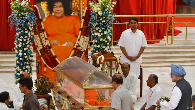 Glassarg des verstorbenen Gurus Sathya Sai Baba, vorne rechts im Bild Trauergast Manmohan Singh (Foto: AP)