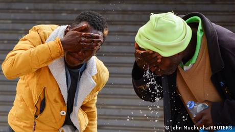 Two demonstrators wash their eyes from burning tear gas, which police used to disperse the protests.