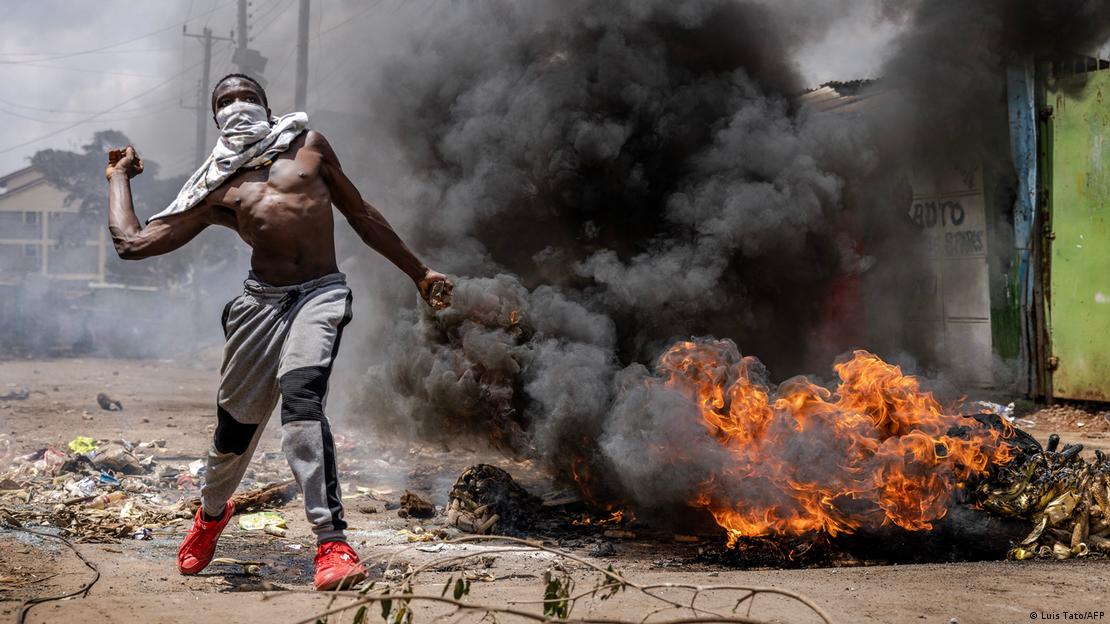 An opposition supporter throws a stone towards police officers during clashes in Nairobi